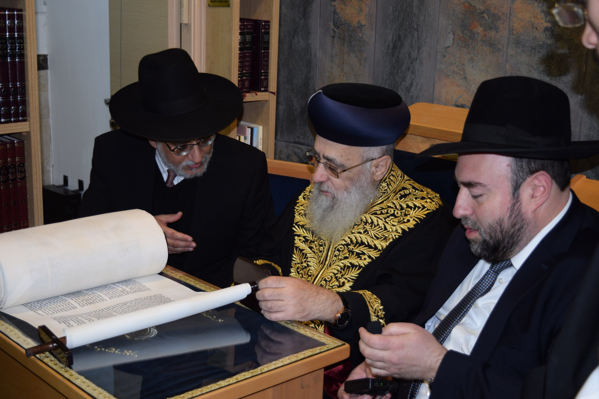 Rabbanim examining a new Sefer Torah at a yeshiva dedication