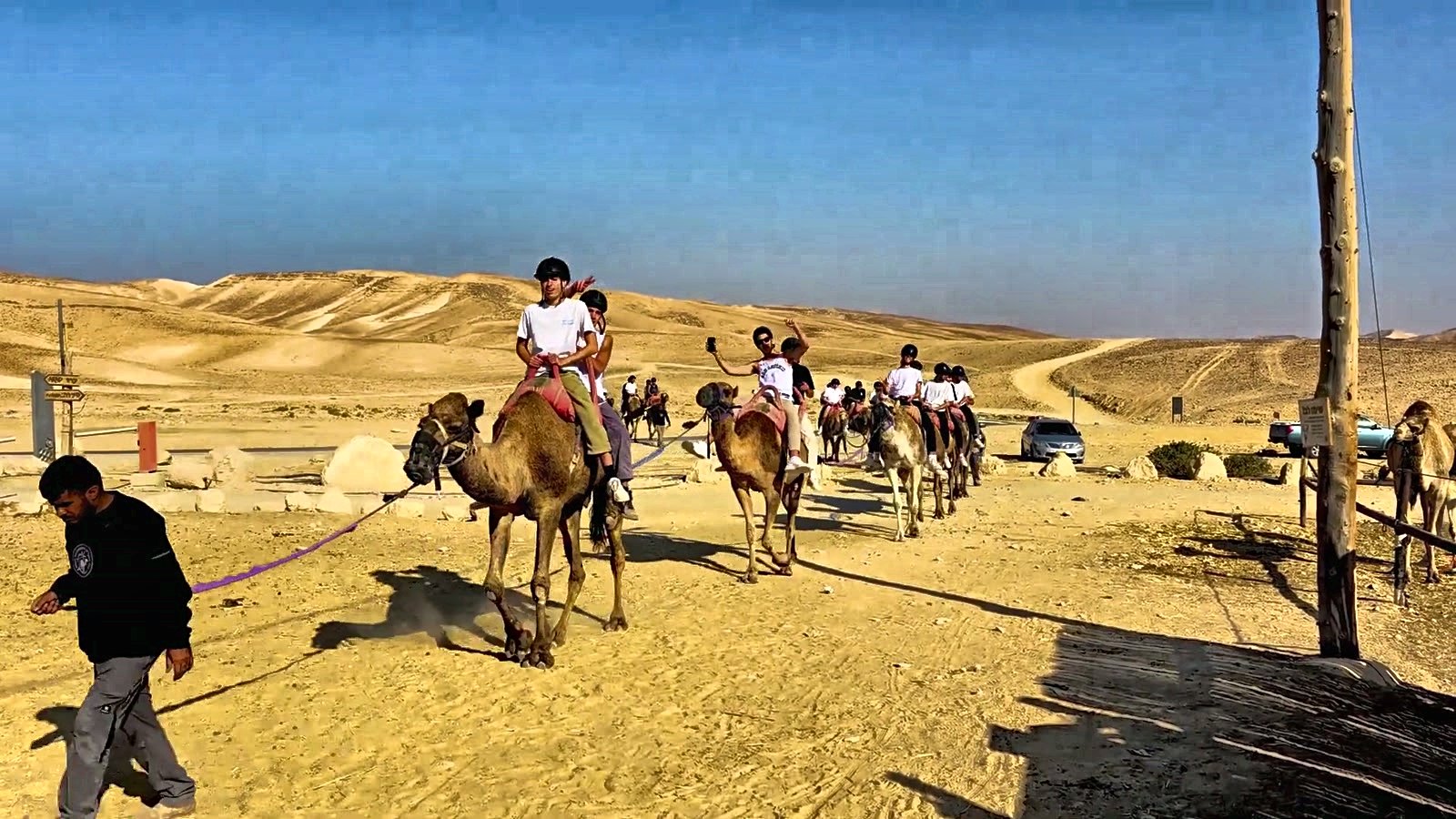 Talmidim riding camels in the desert on a trip