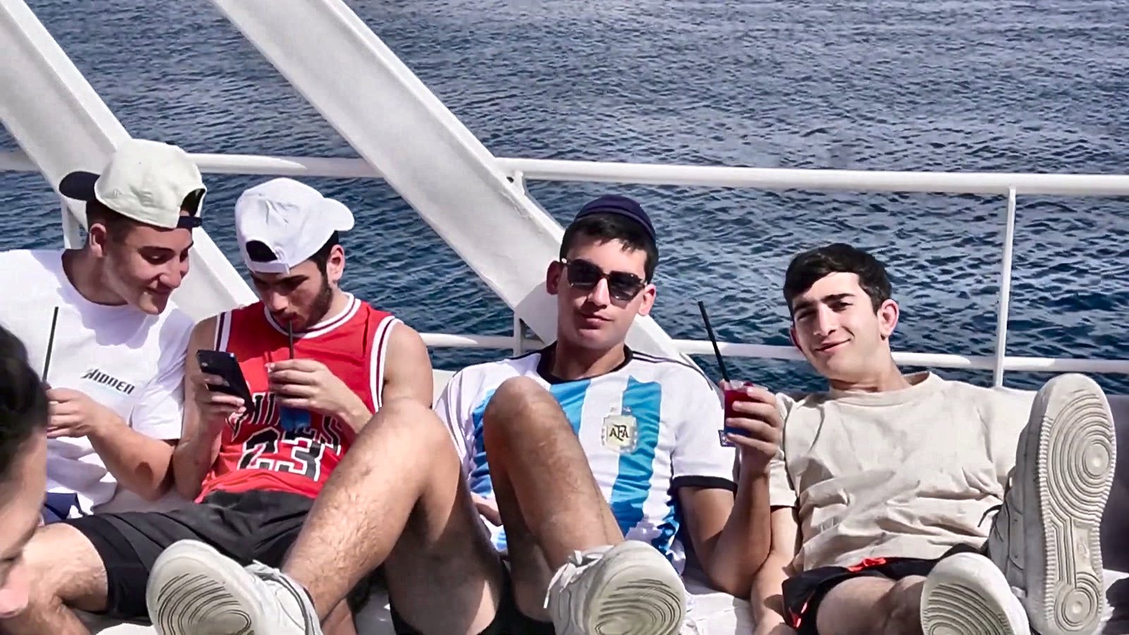 Talmidim relaxing together on the deck of a boat