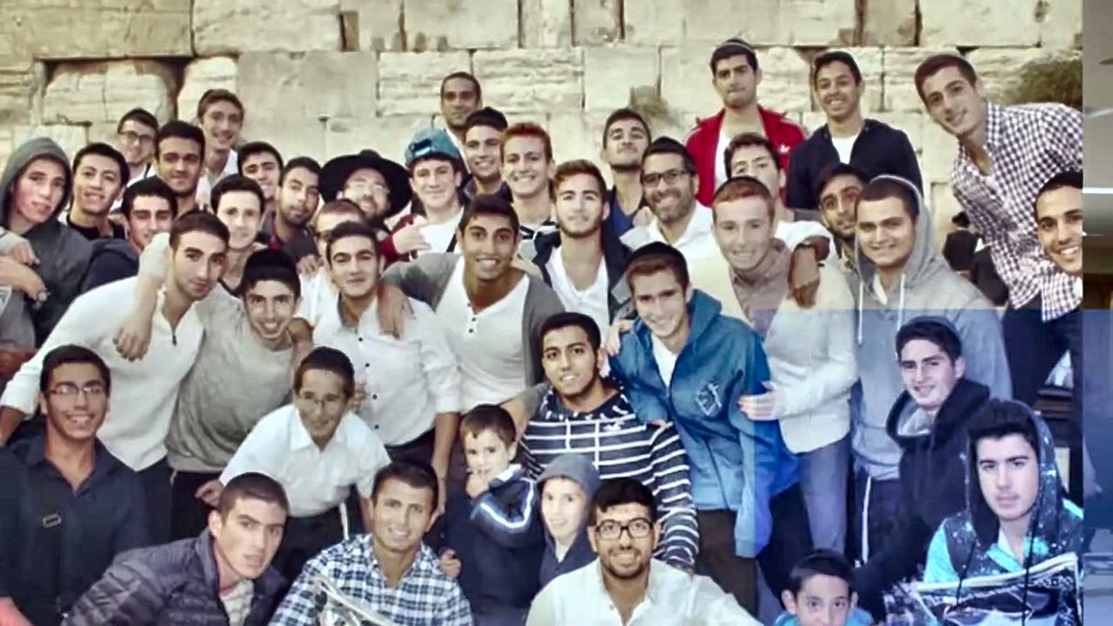 A crowd of talmidim smiling together for a group photo