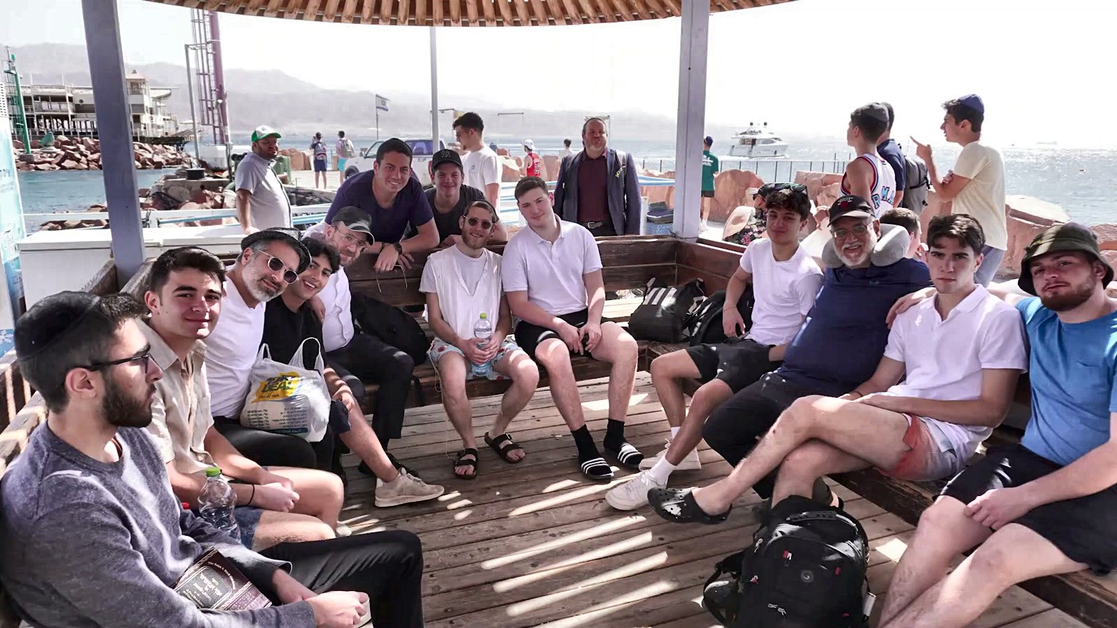 Talmidim sitting together along the shoreline