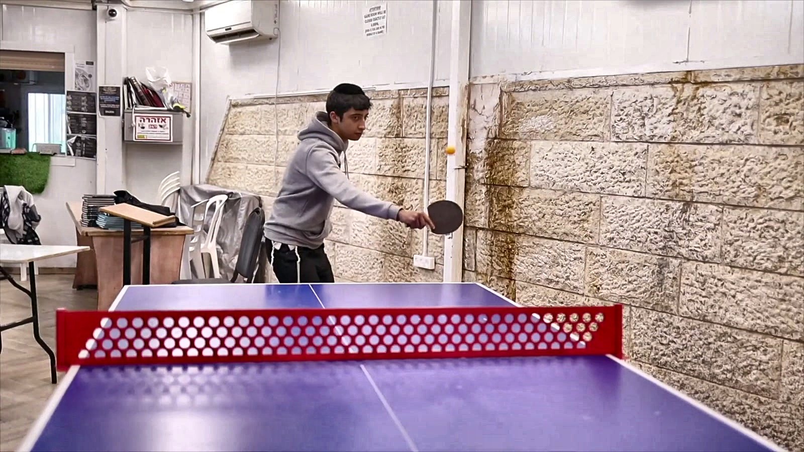 A talmid playing ping pong during a break