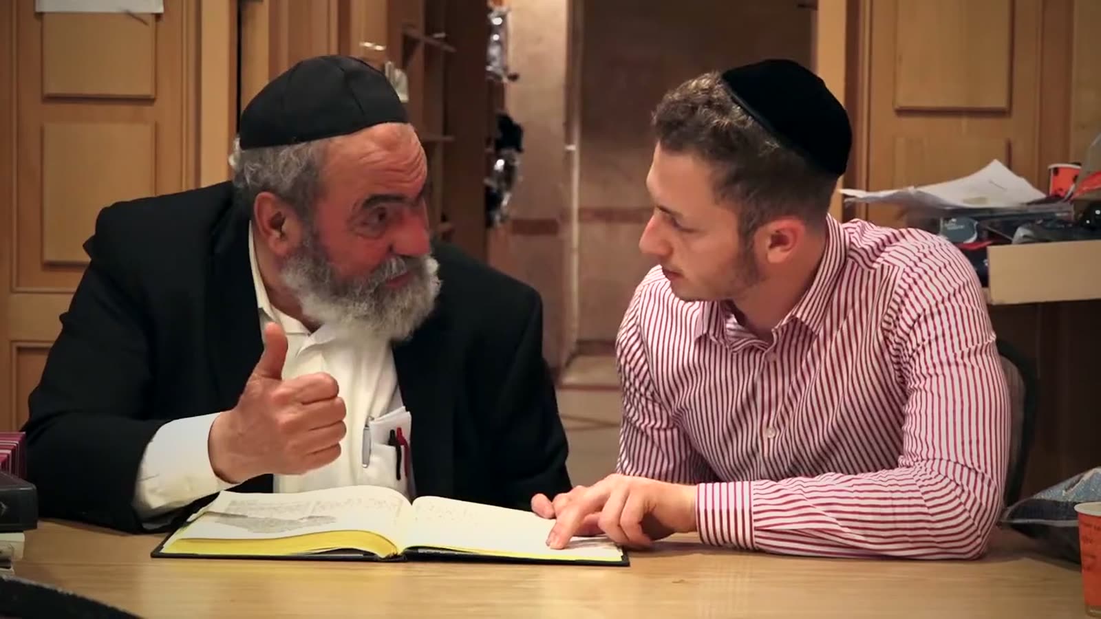 A rav and a talmid learning together over an open Gemara