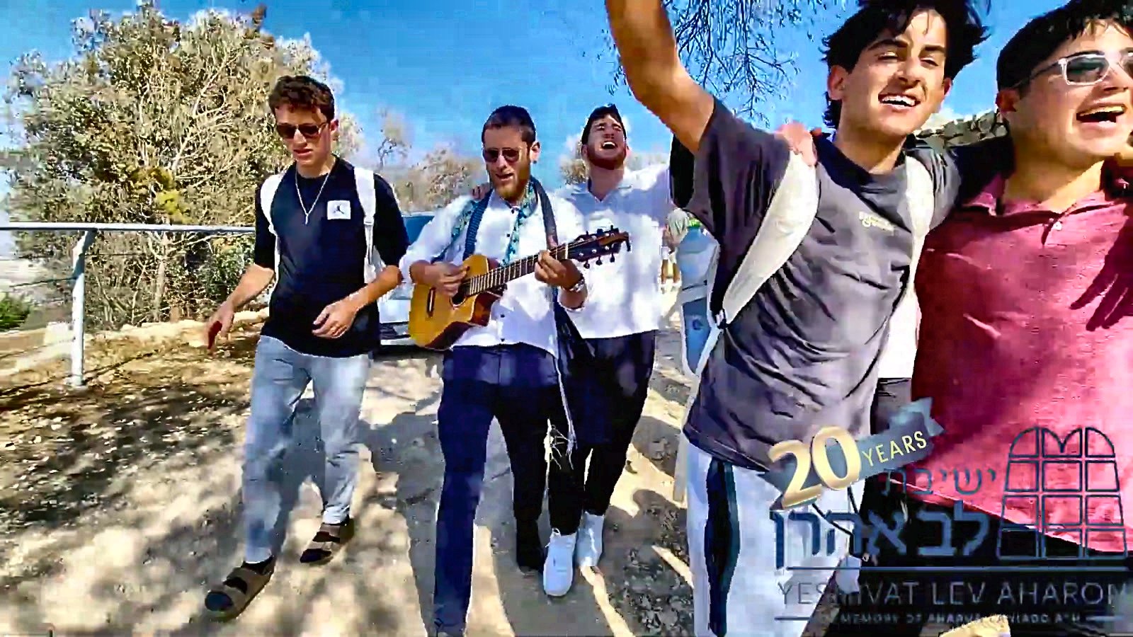 Talmidim singing with arms raised on a trip