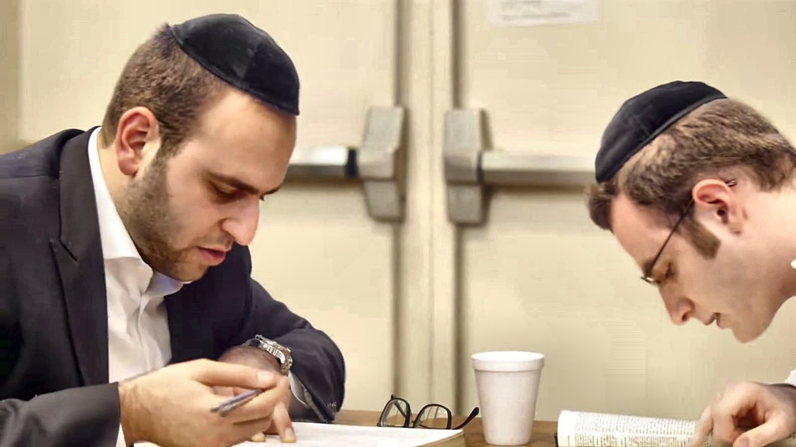 Two talmidim writing and learning side by side